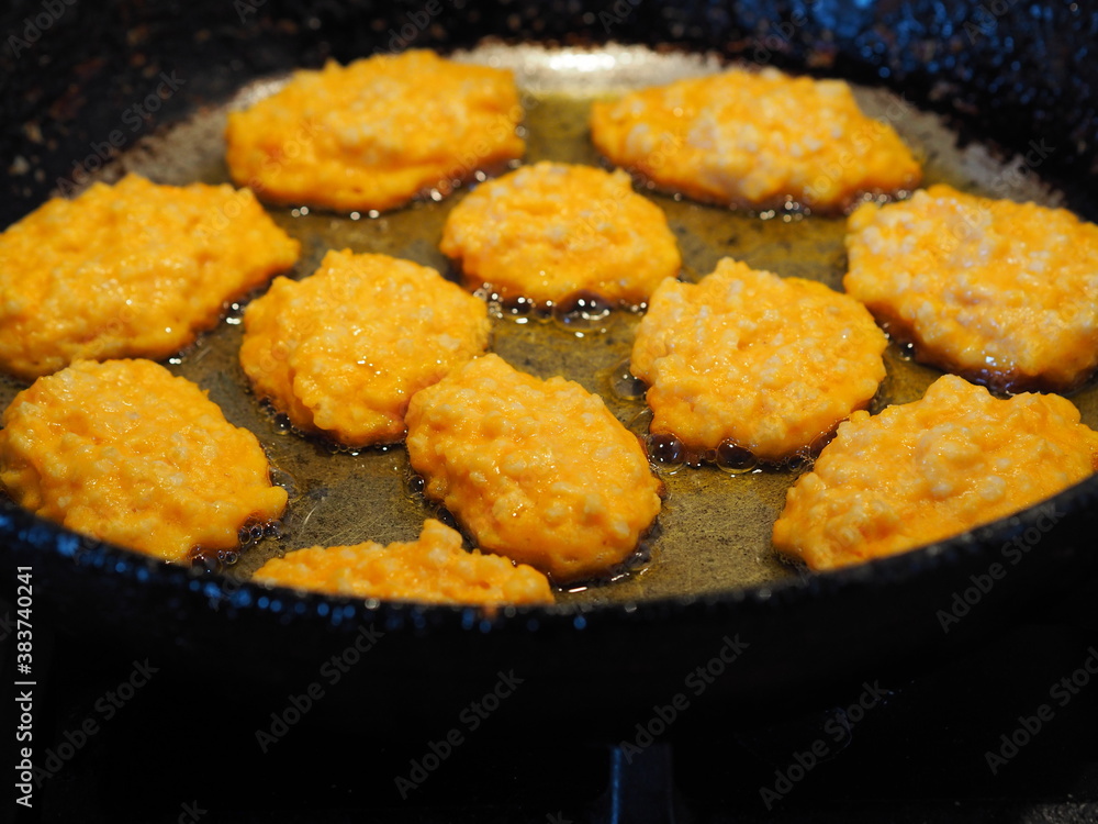 Diet pancakes made from natural pumpkin and millet are fried in a black pan. Home cooking, rustic style Diet pancakes made from natural pumpkin and millet are fried in a black pan. Home cooking, rustic style