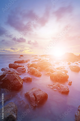 Soft setting sun and wave with sunset over sea and rocks coast © isarescheewin
