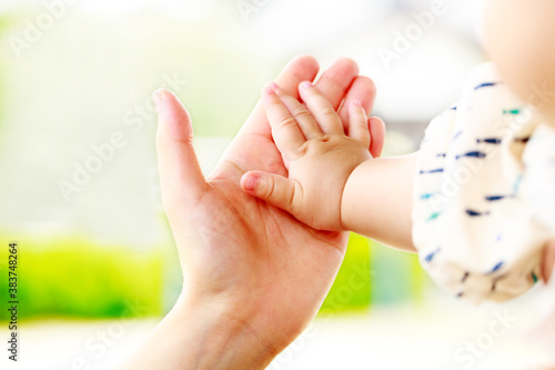 母親と赤ちゃんが手をつなぐ　親子の触れ合い