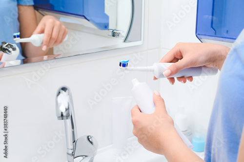 Woman brushing teeth in bathroom