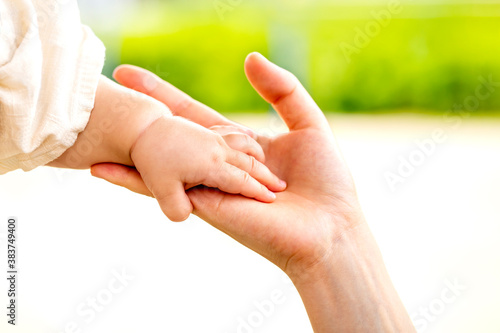 母親と赤ちゃんが手をつなぐ　親子の触れ合い