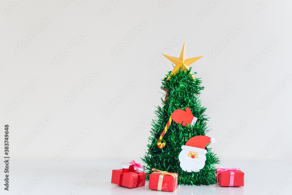 Small Christmas tree, with Christmas decorations and gifts, on white background.