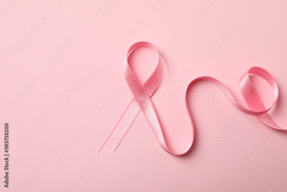Pink awareness ribbon on pink background, close up Pink awareness ribbon on pink background, close up