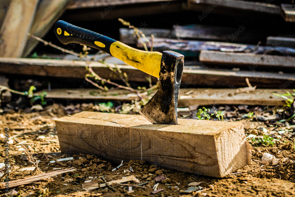 Man chopping wood with an ax, close-up, ax in a deck, soft focus