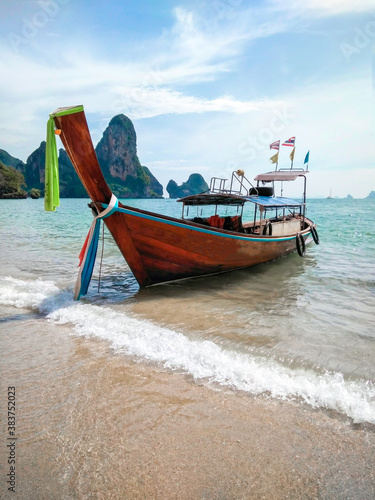 Thai traditional wooden longtail boat and beautiful sand beach. Thailand. © Olga
