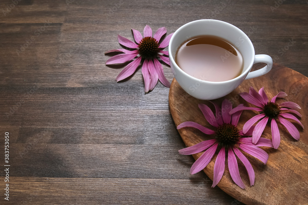 echinacea flowers on wooden background with tea