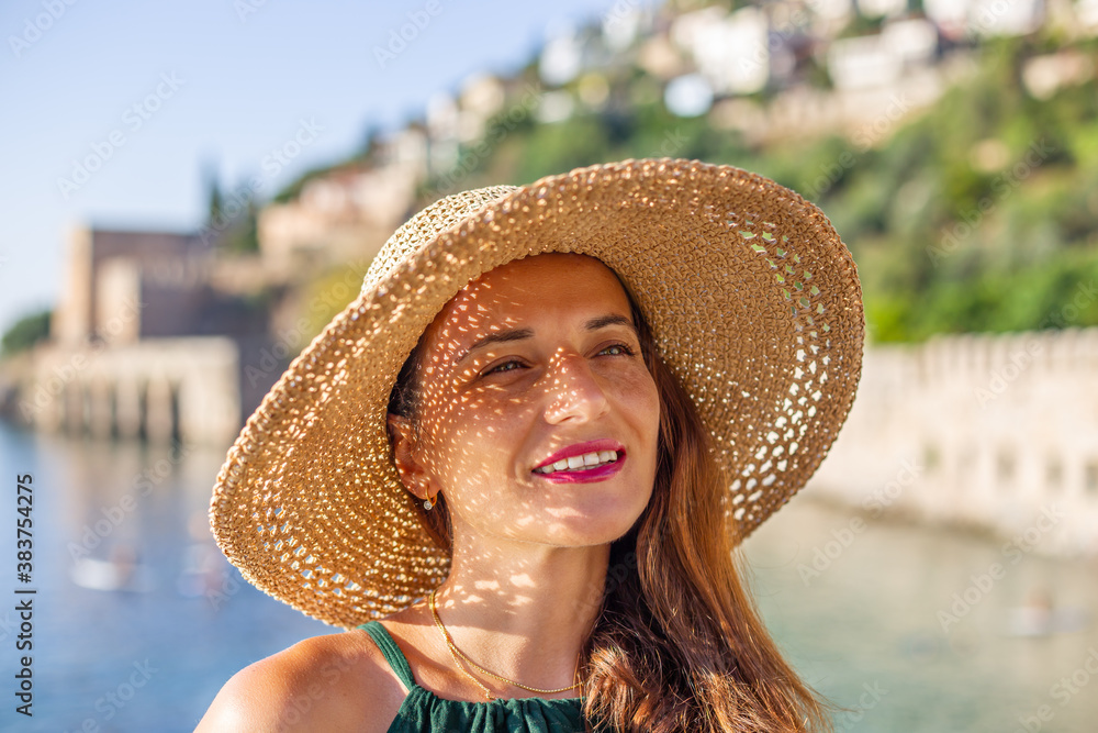 Summer travel concept. Smiling female in straw hat