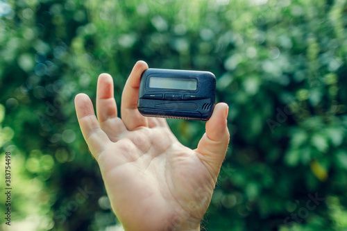 vintage gadget pager. vintage technique. pager in hand on green background photo