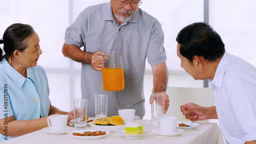 Group of senior friends enjoying eating on dining table. Group of senior friends enjoying eating on dining table.