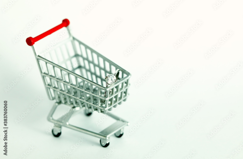Miniature shopping cart model containing ring scene represent shopping concept related idea.