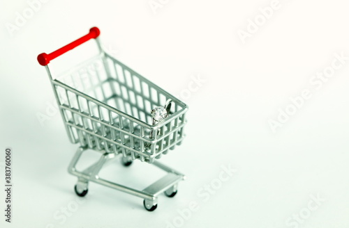 Miniature shopping cart model containing ring scene represent shopping concept related idea. © eurostar1977