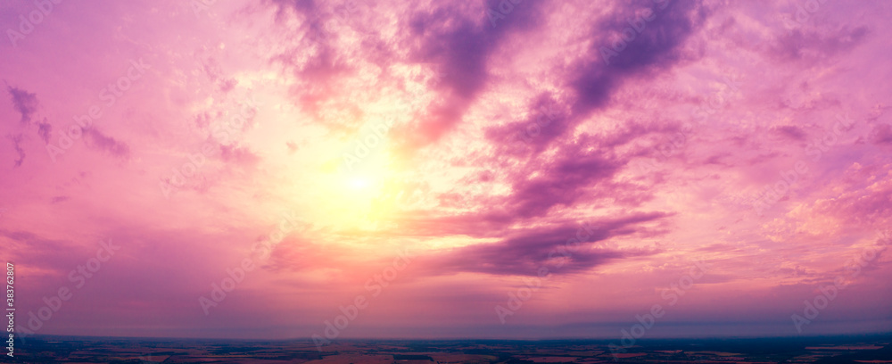 Colorful cloudy sky at sunset over the countryside. Gradient color.