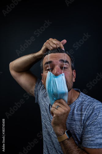 Man putting on mask wrong way