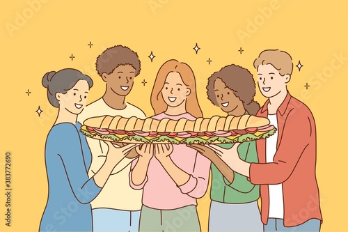 Food, friendship, togetherness, happiness, hunger concept. Group of young international multiethnic friends african american women men sharing large sandwich together. Meal for breakfast lunch dinner.