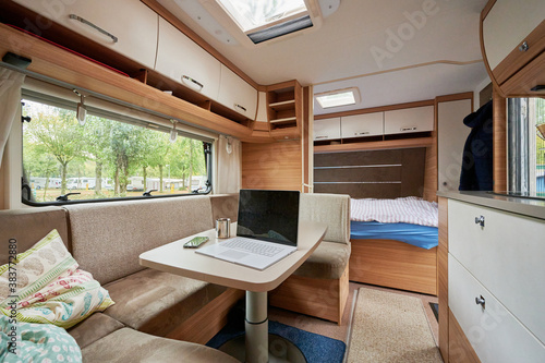Homeoffice Arbeiten im Wohnwagen Wohnmobil mit Laptop und Internet im Urlaub auf dem Campinglatz 