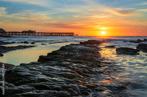 Canvastavla The sun rising behind the pier and the tide receding revealing the rocks on St L