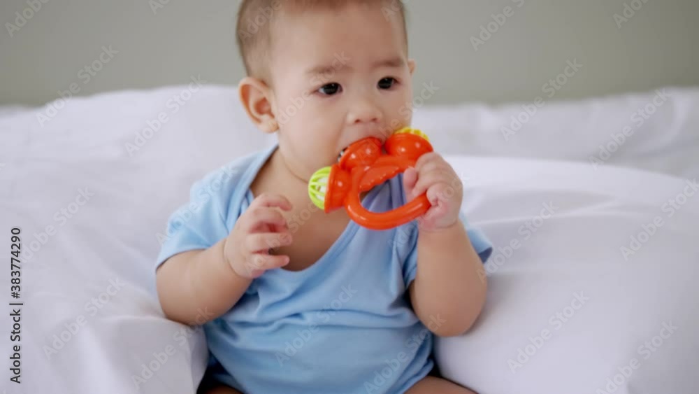 Adorable little baby playing a toy on bed. Adorable little baby playing a toy on bed.