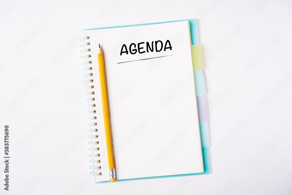 Agenda wordings on a notebook on a table Agenda wordings on a notebook on a table