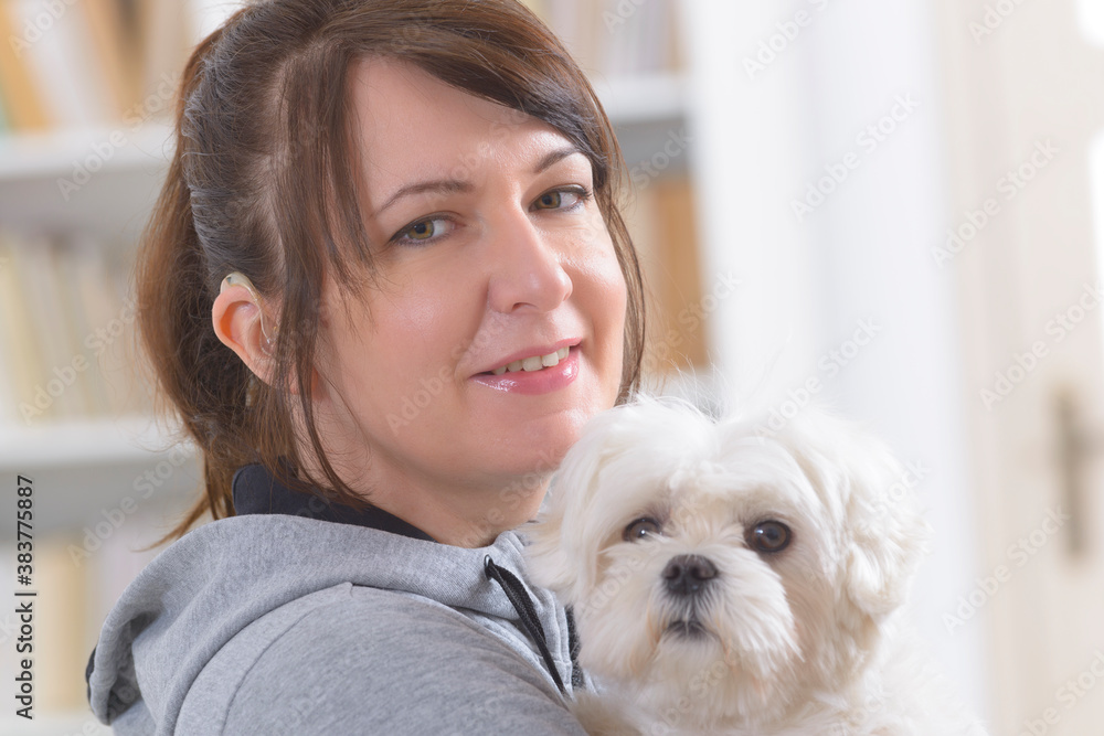 Woman wearing deaf aid with her dog Woman wearing deaf aid with her dog