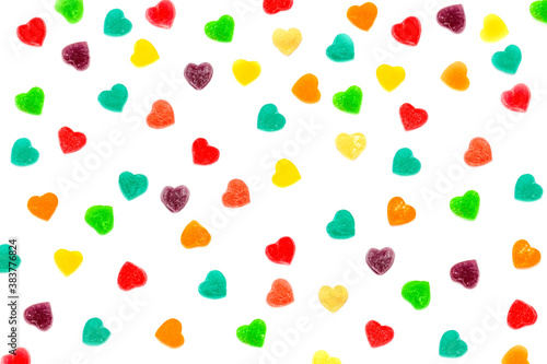 Fototapeta Naklejka Na Ścianę i Meble -  Multi-colored  hearts-shaped jelly candies in sugar on a white background.  Valentine's Day. Dessert. Copy space. View from above