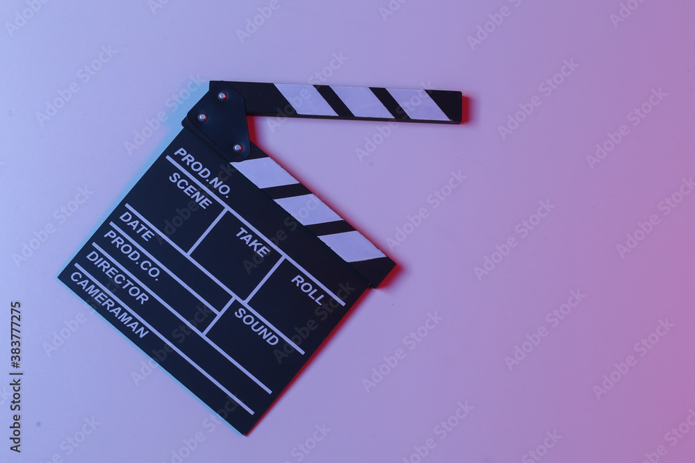 Naklejka premium Film clapper board in blue red neon light. Cinema industry, entertainment