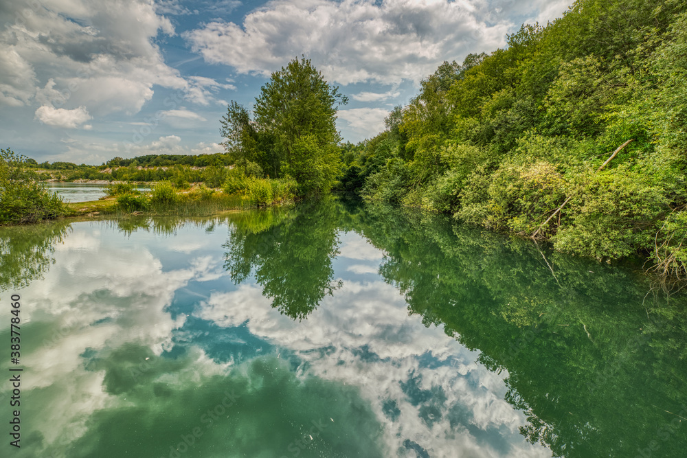 Karlstrup Kalkgrav is a natural lake that formed in an old limestone quarry housing a small heaven. Clouds and vegetation reflect in the water conveying relaxation and peace of mind - Solrod, Denmark Karlstrup Kalkgrav is a natural lake that formed in an old limestone quarry housing a small heaven. Clouds and vegetation reflect in the water conveying relaxation and peace of mind - Solrod, Denmark