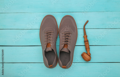 Men's shoes, smoking pipe on a blue wooden background. Gentleman's accessories. Top view