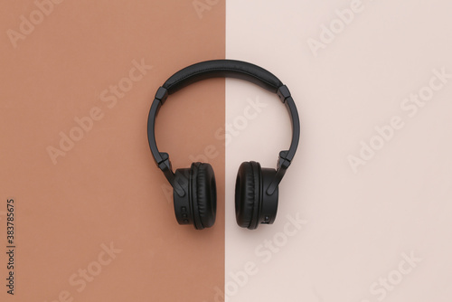 Wireless stereo headphones on brown beige background. Top view