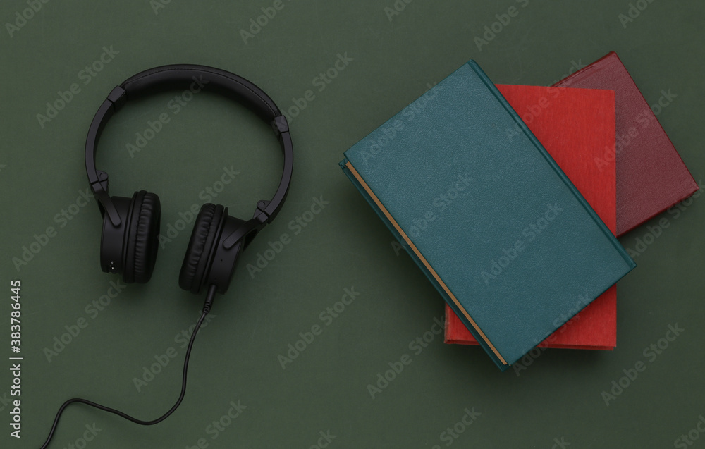 Audio book. Headphones and a books on green background. Top view. Audio book. Headphones and a books on green background. Top view.