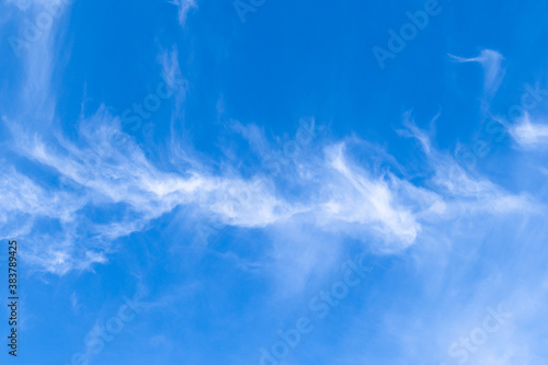 white cirrus cloud high in blue sky on sunny autumn day
