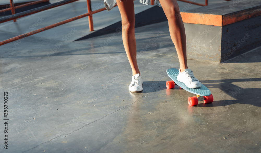 Crop photo of female skater with cruiser board at skatepark Crop photo of female skater with cruiser board at skatepark