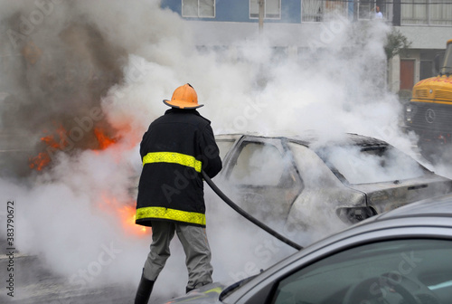 Schilderij op canvas Firefighter extinguishing a car fire. Last stage of a fire