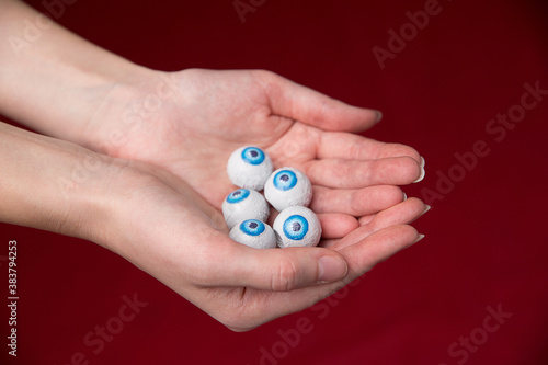 Many eyeballs with blue iris in the palms of the girl. Concept for halloween.