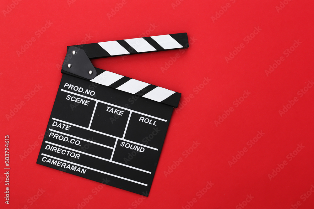 Film clapper board on red background. Cinema industry, entertainment. Top view