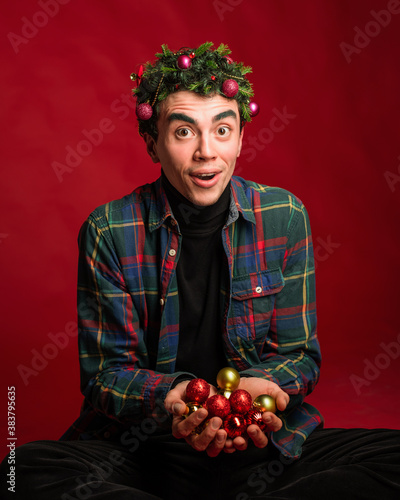 attractive man in a plaid shirt on a red background hair like a christmas tree christmas mood copyspace