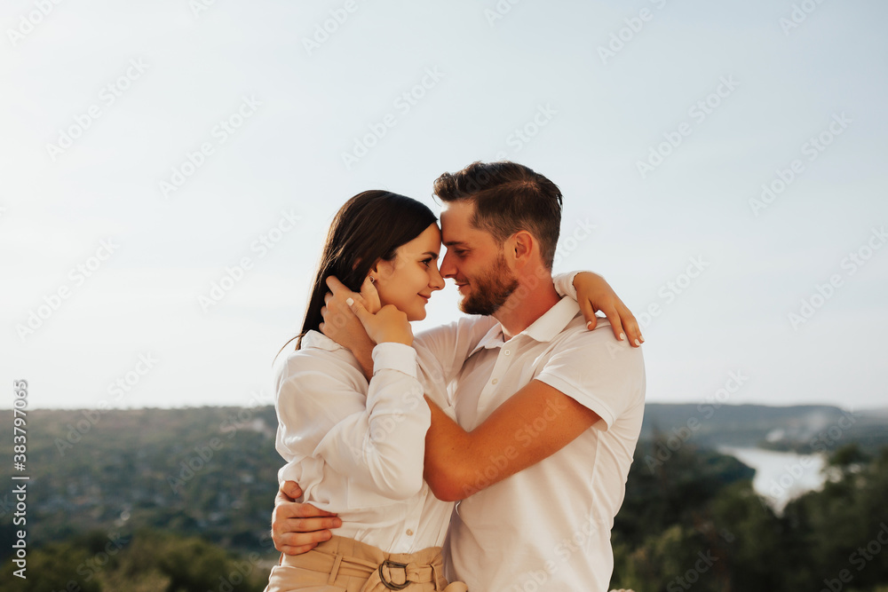 Happy young loving couple are hugging outdoor at sunny day. Concept of people, love and happy lifestyle.