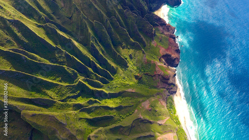 Aerial Na Pali Coast, Kauai Hawaii. These emerald-hued cliffs with razor-sharp ridges tower above the Pacific Ocean, revealing beautiful beaches and waterfalls that plummet to the lush valley floor. 