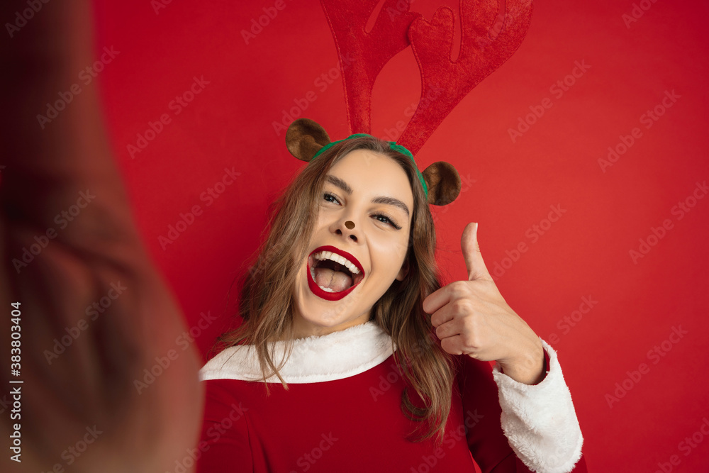 Selfie look. Concept of Christmas, 2021 New Year's, winter mood, holidays. Copyspace for ad, postcard. Beautiful caucasian woman with long hair like Santa's Reindeer catching giftbox. Selfie look. Concept of Christmas, 2021 New Year's, winter mood, holidays. Copyspace for ad, postcard. Beautiful caucasian woman with long hair like Santa's Reindeer catching giftbox.