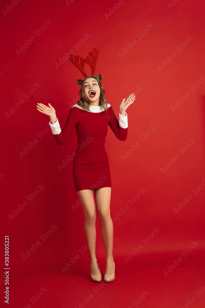 Stylish dancing. Concept of Christmas, 2021 New Year's, winter mood, holidays. Copyspace for ad, postcard. Beautiful caucasian woman with long hair like Santa's Reindeer catching giftbox. Stylish dancing. Concept of Christmas, 2021 New Year's, winter mood, holidays. Copyspace for ad, postcard. Beautiful caucasian woman with long hair like Santa's Reindeer catching giftbox.