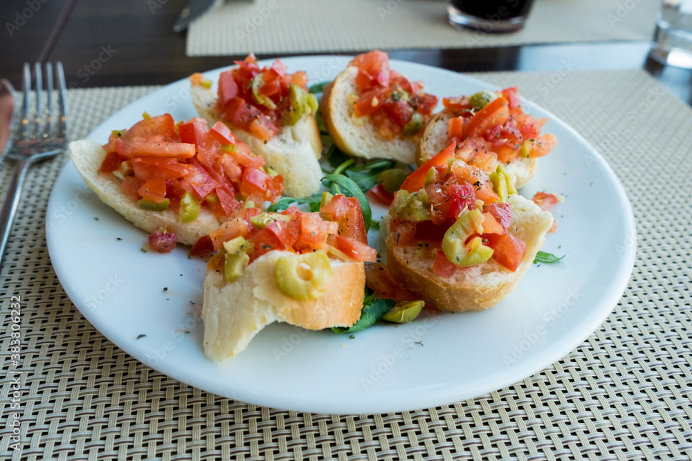 Bruschetta is an antipasto (starter dish) from Italy consisting of grilled bread rubbed with garlic and topped with olive oil ,salt, tomato, garlic basil and herbs Bruschetta is an antipasto (starter dish) from Italy consisting of grilled bread rubbed with garlic and topped with olive oil ,salt, tomato, garlic basil and herbs