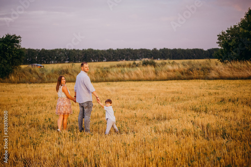 Happy family in the field evening light of a sun.