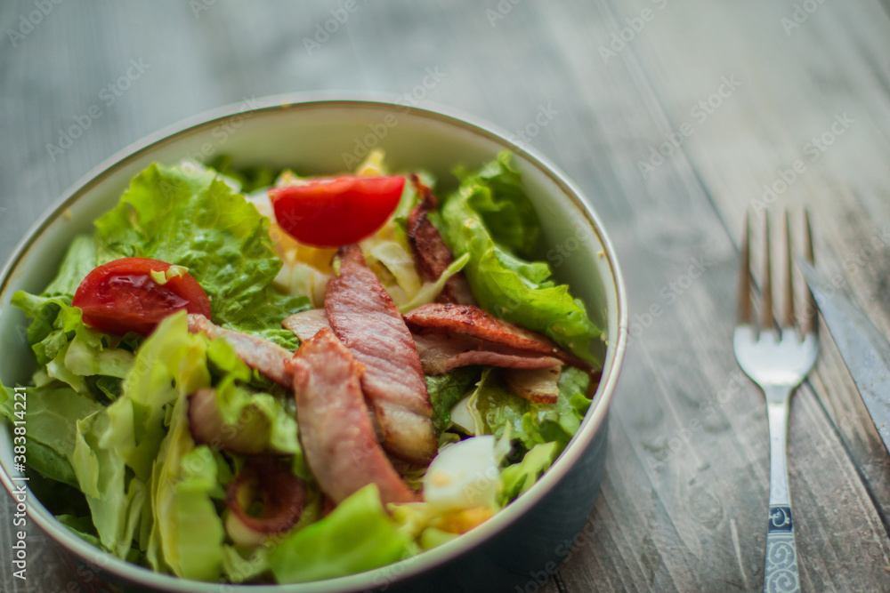 Fresh vegetable salad with slices of bacon. Caesar salad cooked at home Fresh vegetable salad with slices of bacon. Caesar salad cooked at home