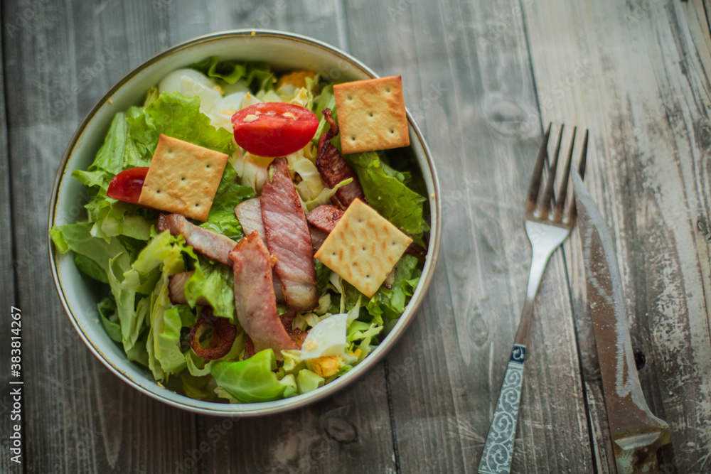 Fresh vegetable salad with slices of bacon. Caesar salad cooked at home Fresh vegetable salad with slices of bacon. Caesar salad cooked at home