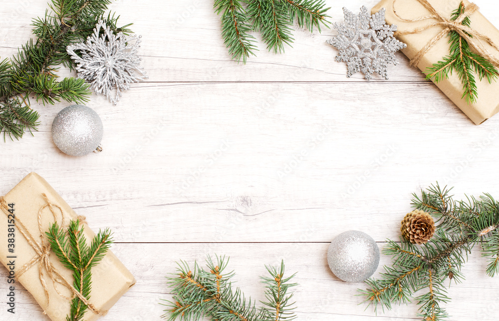 Merry Christmas frame and wallpaper. Happy New Year composition. Christmas gift, balls, pine cones, fir branches on wooden white background. Merry Christmas frame and wallpaper. Happy New Year composition. Christmas gift, balls, pine cones, fir branches on wooden white background.