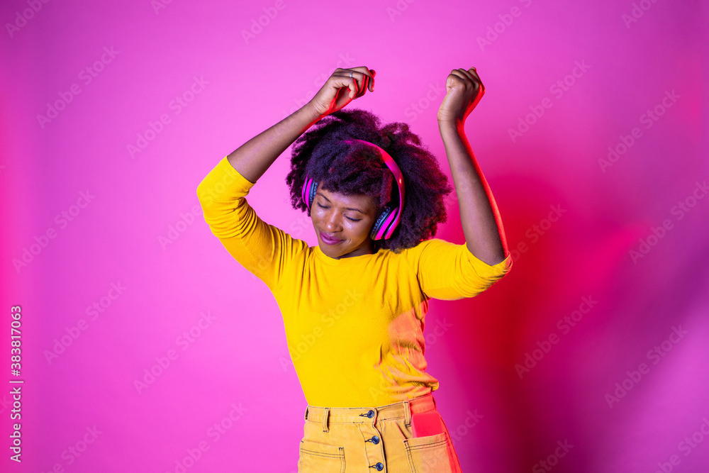 Young beautiful black woman dancing indoor on pink baground holding smartphone - Isolated diverse female clubbing listening streaming music Young beautiful black woman dancing indoor on pink baground holding smartphone - Isolated diverse female clubbing listening streaming music