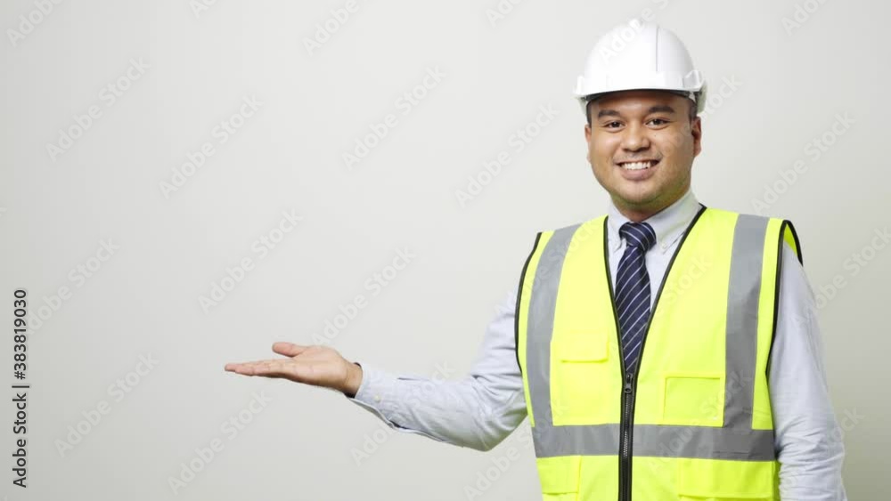 Asian worker in uniform hard hat open hands palm up pointing to blank space for advertise text or mockup in studio isolated white background. 4k resolution. Asian worker in uniform hard hat open hands palm up pointing to blank space for advertise text or mockup in studio isolated white background. 4k resolution.
