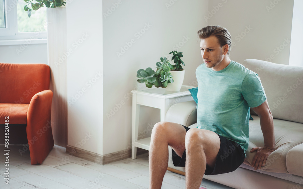 Caucasian blonde man is training at home without equipment wearing sportswear during the fitness exercises