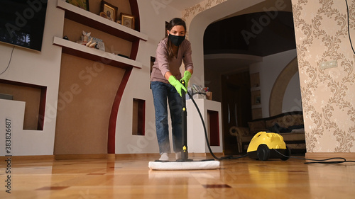 A young girl disinfects the floor with a steam generator
