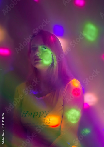 A girl in club lighting with a thoughtful face