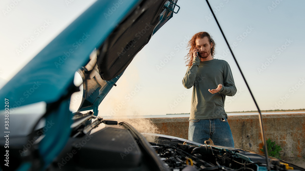 Εκτύπωση καμβά Young man talking on the phone with car service, assistance or tow truck while s